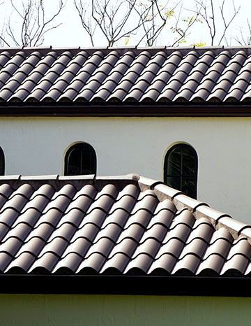Graphite clay barrel roof tiles on a stylish, elegant home with arched windows.